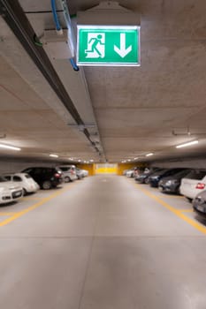 Green emergency exit sign on white in the parking car.  image for background, copy space, objects, illustration and article