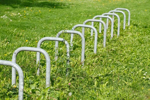 Empty metal bike racks on a green field