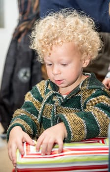 a little blond boy opens his presents