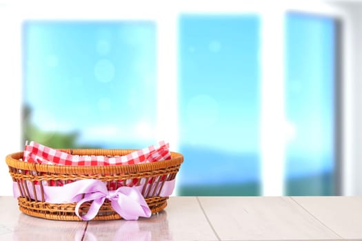 Empty basket with purple ribbon on wooden table with bright blurred natural background. For your food and product display montage.