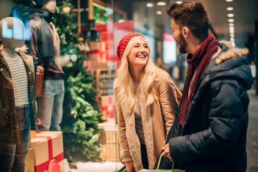 Side view of two mid-adult people window shopping at chirtsmas time.