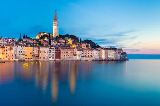 Colorful sunset of Rovinj town, Croatian fishing port on the west coast of the Istrian peninsula. Colorful evening seascape of Adriatic Sea. Traveling concept.