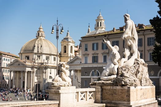 Sculptures and churches on Piazza del Popolo, People's Square, in Rome, Italy.