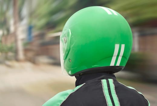 Rear view of motorcycle taxi ride with fast on the urban street