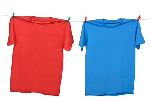Red and blue clothes hanging on the clothesline isolated over white background