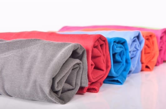 Row of rolled clothes isolated over white background