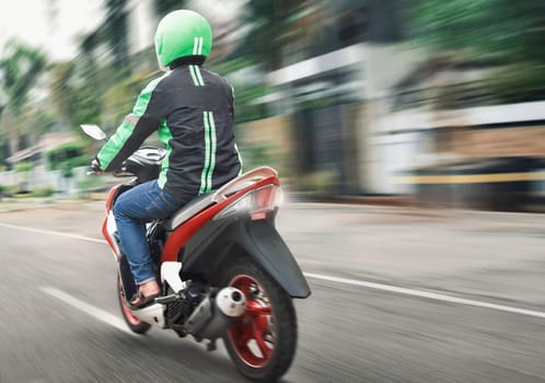 Rear view of motorcycle taxi ride with fast on the urban street