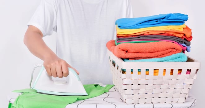 Man ironing clothes on ironing board isolated over white background
