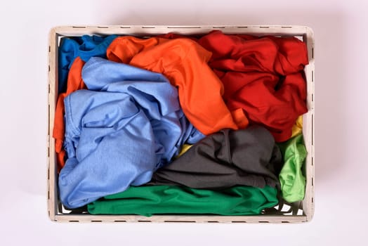 Top view of laundry basket with dirty clothes isolated over white background