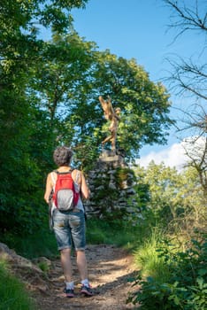 a woman hiker on mountain trail, back view