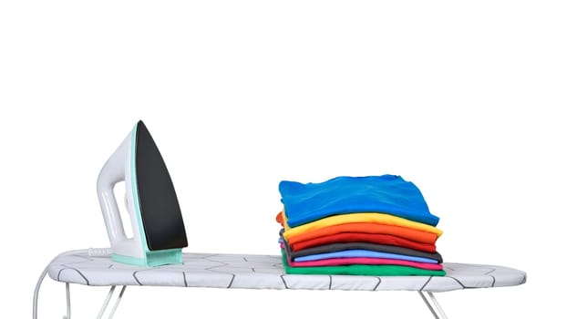 Stack of tidy clothes and a iron on ironing board isolated over white background