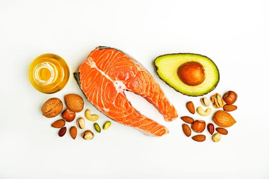 Selection of healthy fat food. Raw steak of salmon with fresh ingredients with high-fat benefits