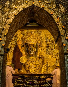The ritual of daily face washing Mahamuni Buddha in Mandalay, Myanmar