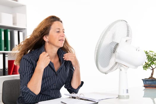 business woman with ventilator at his desk in summerly hot office