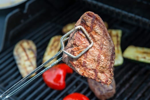 beef steak with different vegetables on barbecue