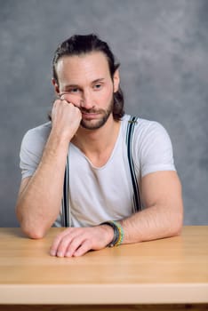 young man looking sad in front of gray background