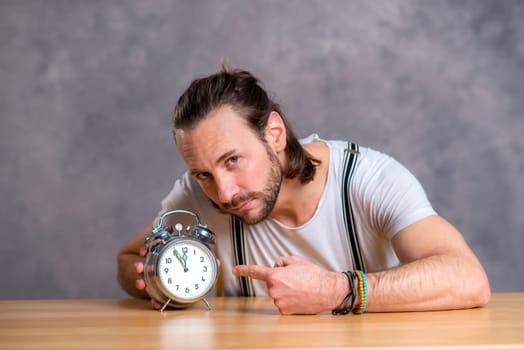 young man man with clock in front of gray background