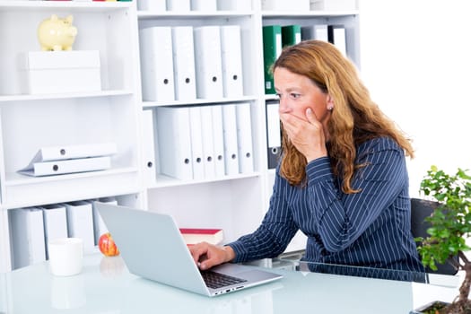 young  business woman looking shocket on her computer screen