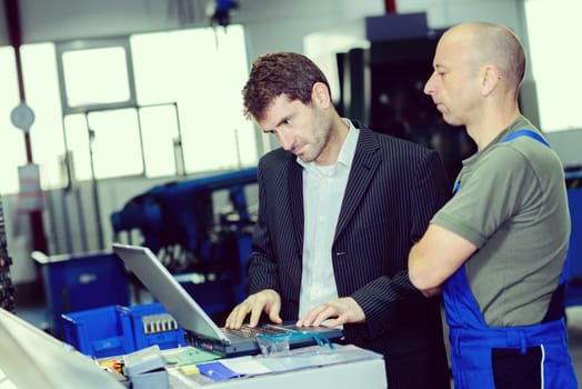 in the factory-  boss and worker on work bench
