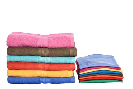 Pile of tidy clothes and folded towels isolated over white background