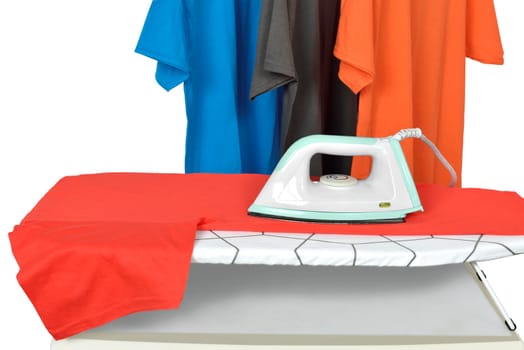 Clothes on ironing board with electric iron isolated over white background