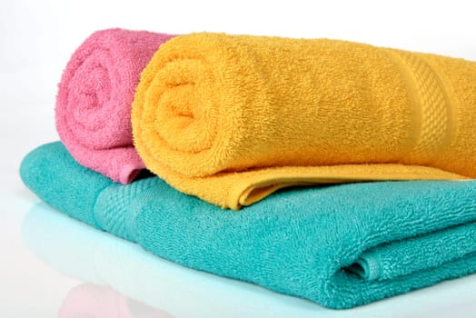 Colorful towels folded and rolled up a isolated over white background