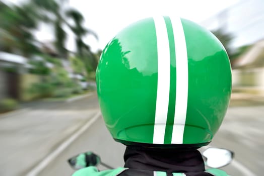 Rear view of motorcycle taxi ride with fast on the urban street