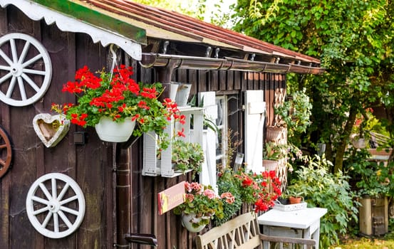 Wooden hut garden hut with flowers in summer Bavaria
