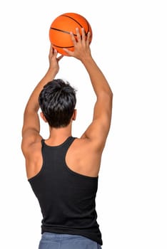 Portrait of a young basketball player passing the ball. Young caucasian boy in sportswear playing basketball on white background with copyspace