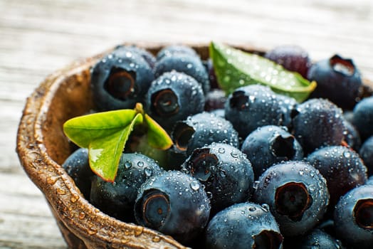 Fresh blueberries with leaf in a bowl close up. Concept for healthy eating and nutrition
