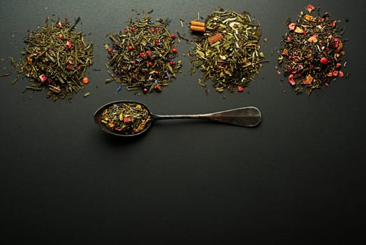 Dry tea collection and spices of different types on black background