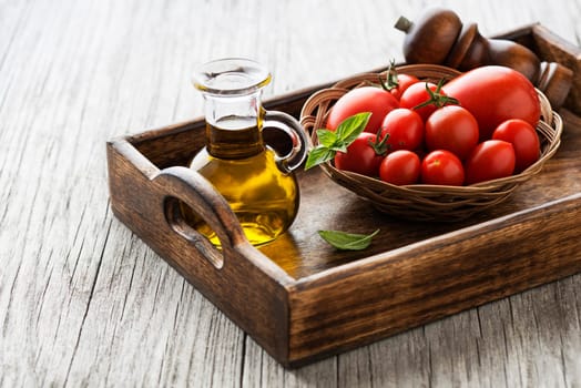 Fresh cherry tomatoes with basil leaves and olive oil. Concept for a tasty and healthy meal.