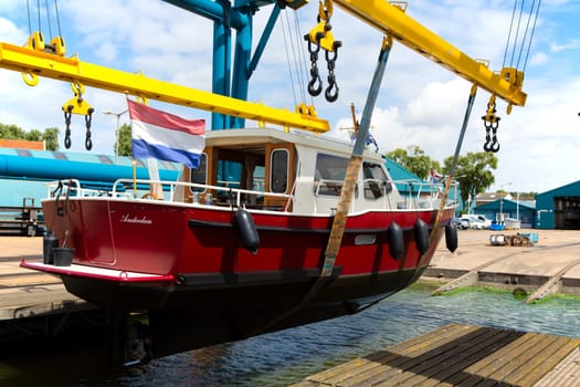 Boat crane lifting a motorboat.