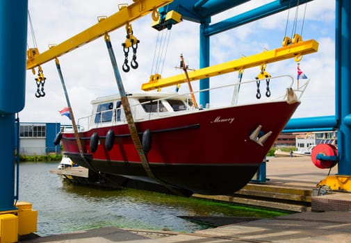 Boat crane lifting a motorboat.