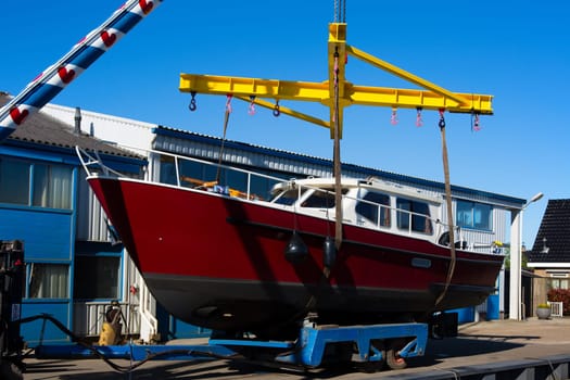Boat crane lifting a motorboat.