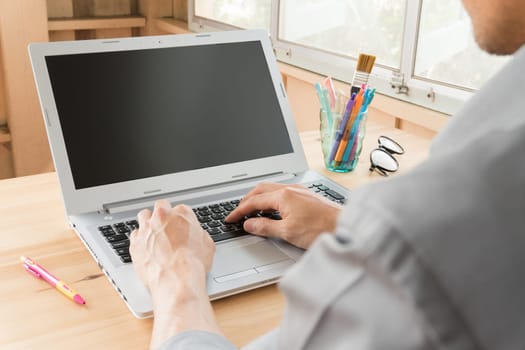 Gray shirt businessman typing laptop or notebook in home office. Small business SME or start up businessman concept. Business and .technology about communication or contact