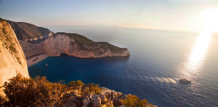 Navagio beach with shipwreck against sunset on Zakynthos island in Greece