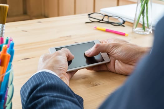 Businessman in suit chat smartphone or mobile phone in home office. Smartphone or mobile phone and pen and laptop and eyeglasses. Social or internet and technology communication concept