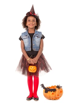 Girl in Halloween witch costume with pumpkin over a white background