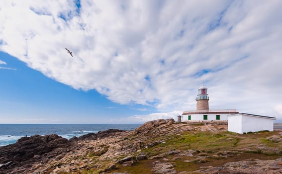 Marine landscape with lighthouse,sea,cliff and cloudy sky. Galizia, Spain.