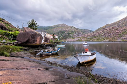 Landscape with fishing boats moored  on shore. Galicia Spain.