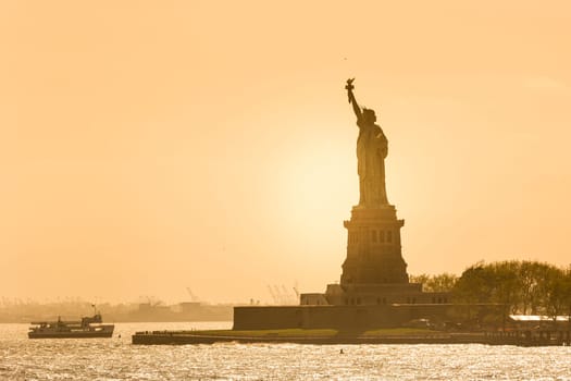 Statue of Liberty silhouette in sunset, New York City, USA.