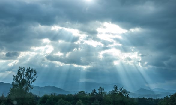 dramatic dark clouds and sun beams landscape