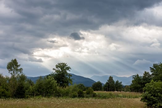 dramatic dark clouds and sun beams landscape