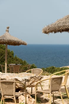 Chairs and parasols for guests of the old defence tower of Punta de N'Amer near Sa Coma, on the Spanish Balearic Mediterranean island of Mallorca