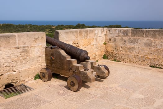 Old antique iron cannon on the old defence tower of Punta de N'Amer near Sa Coma, on the Spanish Balearic Mediterranean island of Mallorca