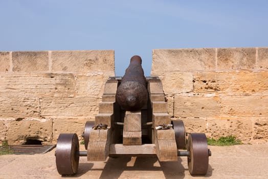Old antique iron cannon on the old defence tower of Punta de N'Amer near Sa Coma, on the Spanish Balearic Mediterranean island of Mallorca