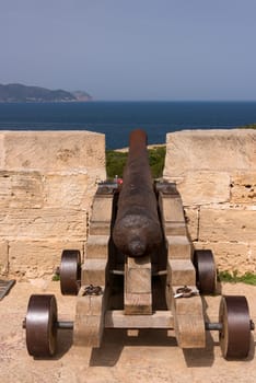 Old antique iron cannon on the old defence tower of Punta de N'Amer near Sa Coma, on the Spanish Balearic Mediterranean island of Mallorca