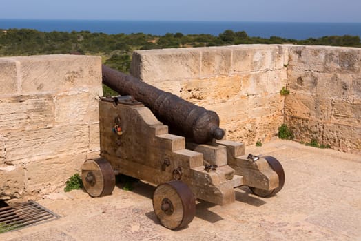 Old antique iron cannon on the old defence tower of Punta de N'Amer near Sa Coma, on the Spanish Balearic Mediterranean island of Mallorca