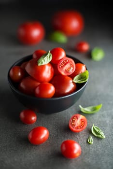 Fresh cherry tomatoes with basil leaves. Concept for a tasty and healthy meal.